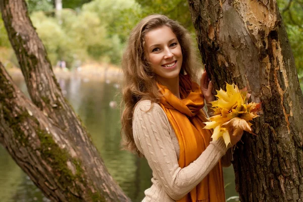 Giovane donna sorridente nel parco d'autunno — Foto Stock