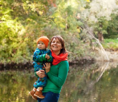 Mutlu aile sonbahar parkında eğleniyor.