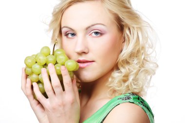 Sarışın kadın elinde bir demet üzüm tutuyor.