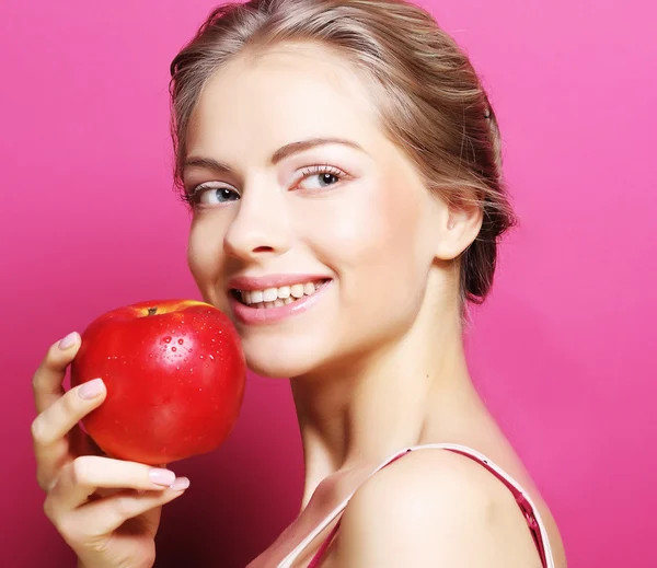 Woman with apple over pink background — Stock Photo, Image