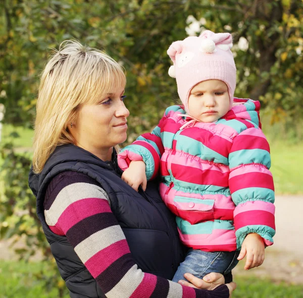 Glad mamma med en dotter i höst park — Stockfoto