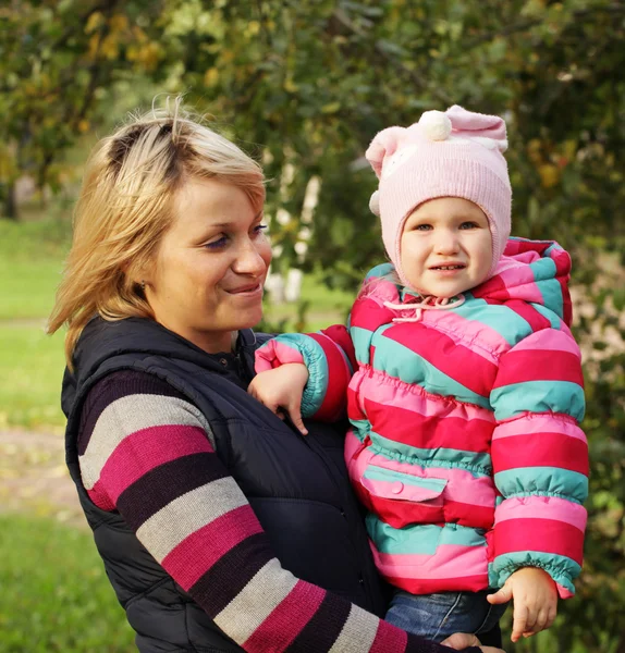 Madre feliz con una hija en el parque de otoño — Foto de Stock