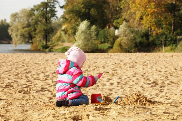 Dziewczynka gra z piasku na plaży jesień — Zdjęcie stockowe