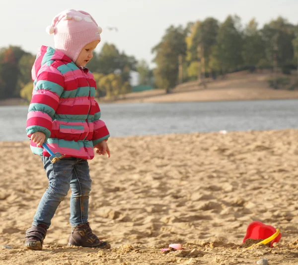 Dziewczynka gra z piasku na plaży jesień — Zdjęcie stockowe