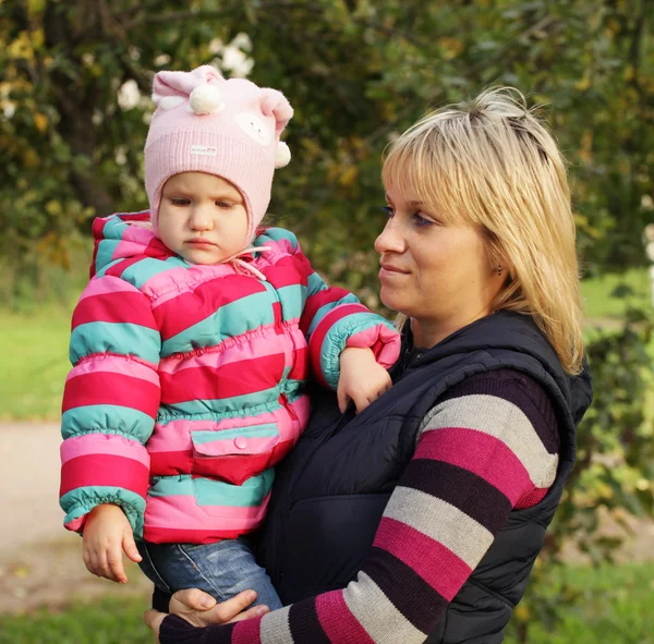 Glad mamma med en dotter i höst park — Stockfoto