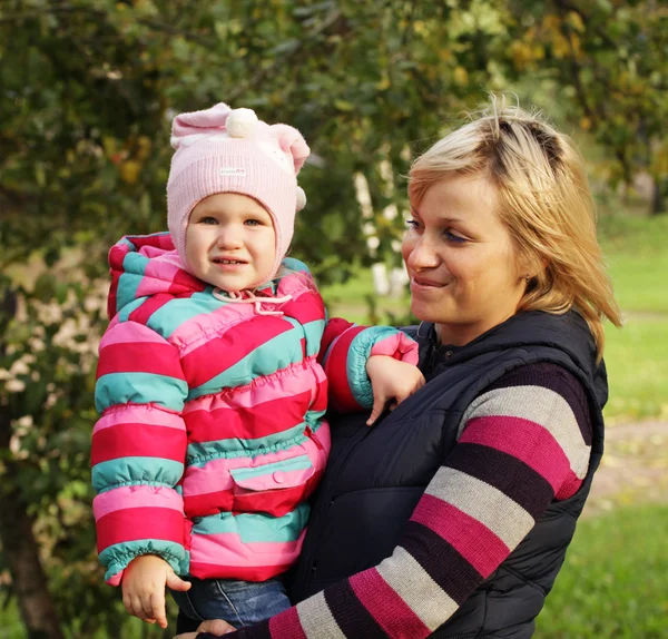 Madre feliz con una hija en el parque de otoño — Foto de Stock