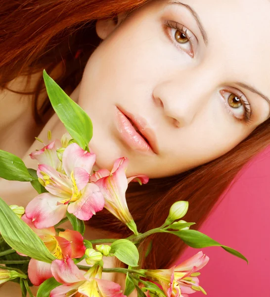 Young beautiful woman with pink flowers — Stock Photo, Image