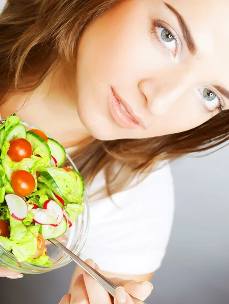 Ragazza sorridente con un'insalata su uno sfondo bianco — Foto Stock