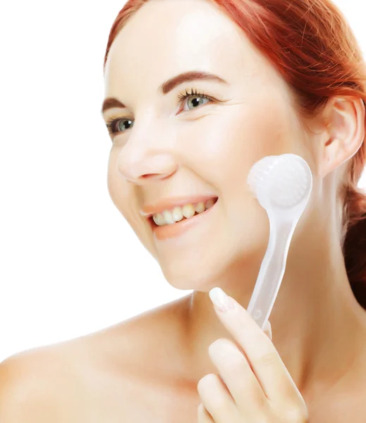 Girl cleaning face with peeling brush — Stock Photo, Image