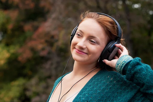 Наслаждаясь музыкой в осеннем парке — стоковое фото