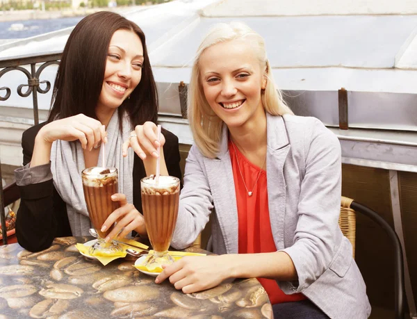 Des femmes souriantes buvant un café assis — Photo