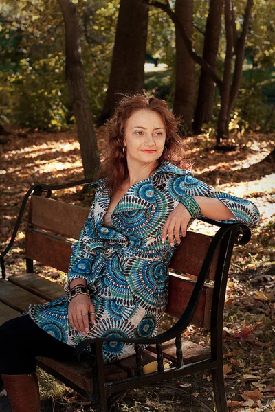 Chica en el banco en el parque de otoño — Foto de Stock