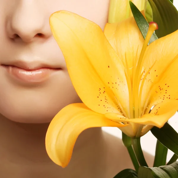 Schönheit Frau Gesicht mit gelben Lilie Blume — Stockfoto