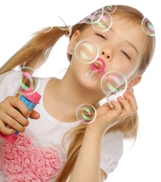 Funny lovely little girl blowing soap bubbles — Stock Photo, Image