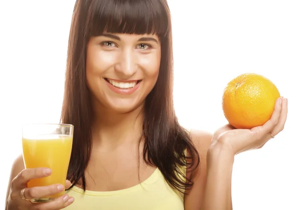 Mulher segurando laranja e suco — Fotografia de Stock