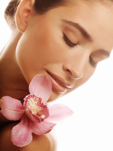 Mujer joven con orquídea rosa — Foto de Stock