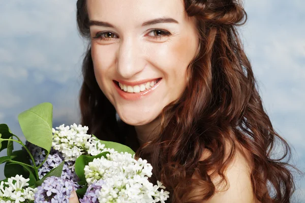 Eflatun çiçekler ile güzel bir kadın — Stok fotoğraf