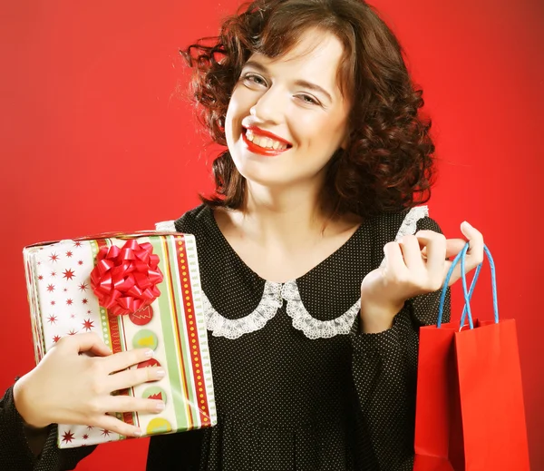 Happy woman with shopping bag and gift. — Stock Photo, Image