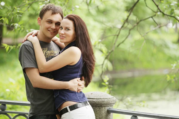 Couple walking on a bridge in a park — Stock Photo, Image