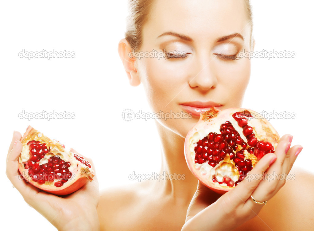 Woman showing pomegranate smiling.