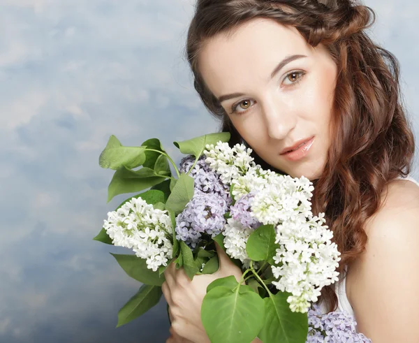 Mulher bonita com flores lilás — Fotografia de Stock