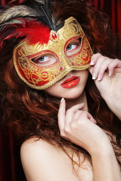 Jovem mulher em uma máscara misteriosa vermelha — Fotografia de Stock