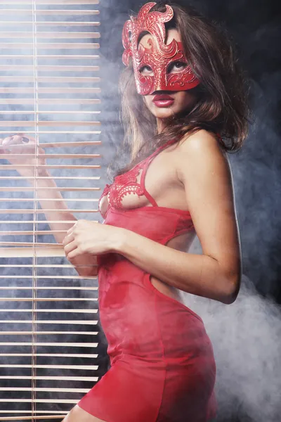 Jolie femme en rouge avec masque Image En Vente