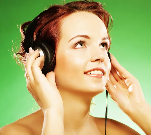 Kvinna med hörlurar lyssnar på musik — Stockfoto
