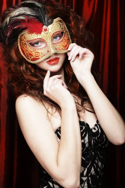 Giovane donna in una maschera misteriosa rossa — Foto Stock