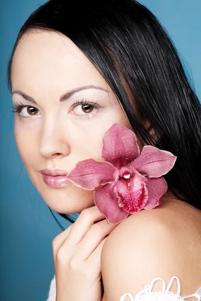 Młoda piękna kobieta z różowym kwiatem — Zdjęcie stockowe