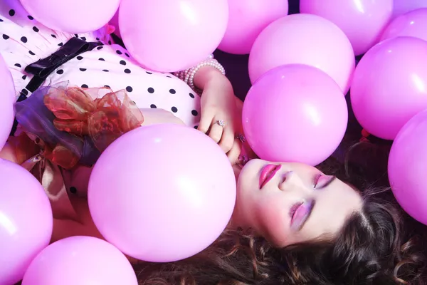 Sleeping woman lying on floor among balloons — Stock Photo, Image