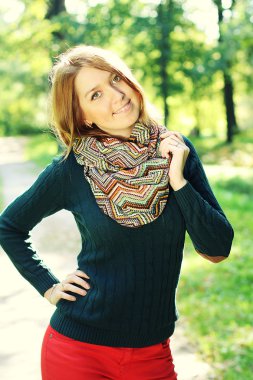 Genç ve güzel bir kadın sonbahar parkında dinleniyor.