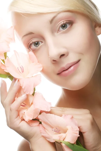 Mujer con flores de gladiolo en las manos — Foto de Stock