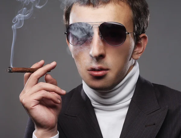 Mann trägt Sonnenbrille und raucht Zigarette. — Stockfoto