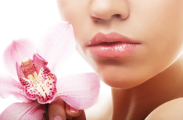 Jovem mulher com orquídea rosa — Fotografia de Stock