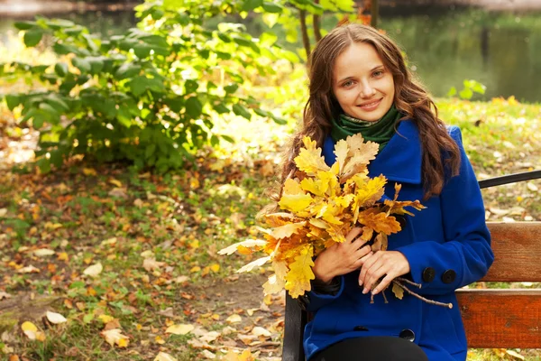 年轻优雅的女人，有秋天的叶子 — 图库照片
