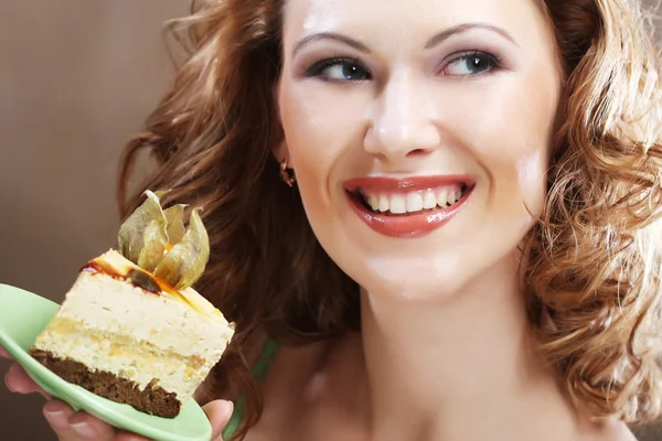 Junge Frau hält ein leckeres Stück Kuchen hoch — Stockfoto