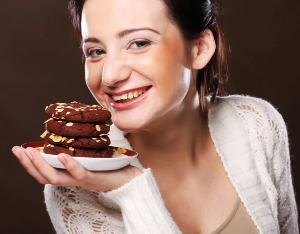 Donna che mangia biscotti al cioccolato — Foto Stock