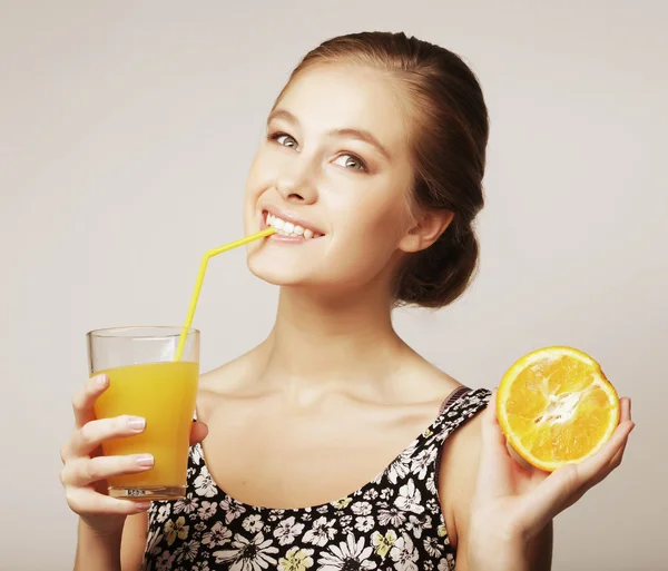 Mulher segurando suco de laranja e laranja — Fotografia de Stock