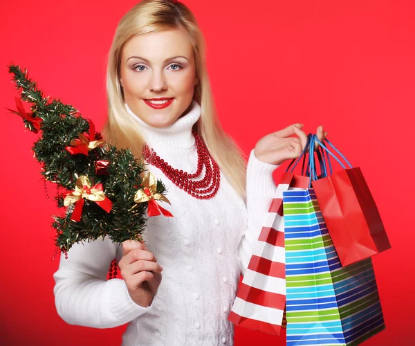 Mujer sosteniendo regalo y el árbol — Foto de Stock