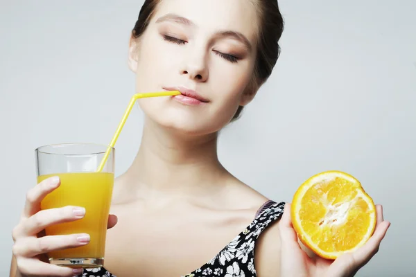 Donna con succo d'arancia e arancia — Foto Stock