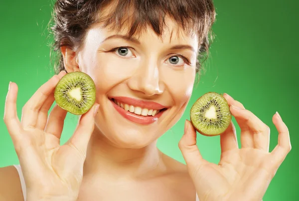 Mladý usmívající se žena hospodářství kiwi. — Stockfoto