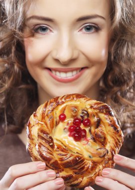 Elinde pasta olan genç bir kadın.