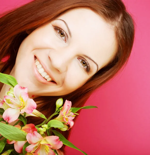 Jeune belle femme avec des fleurs roses — Photo