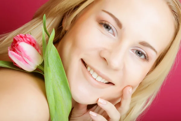 Blond kvinna med rosa tulpan — Stockfoto