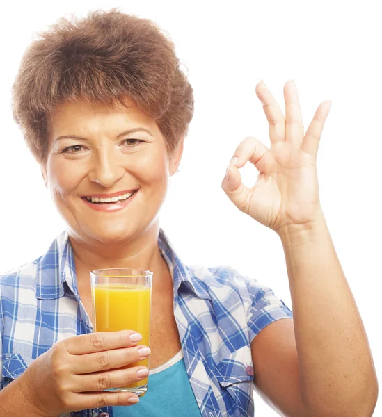 Mature woman holding a glass of orange juice — Stock Photo, Image