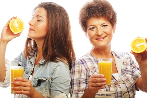 Madre e hija bebiendo jugo de naranja —  Fotos de Stock