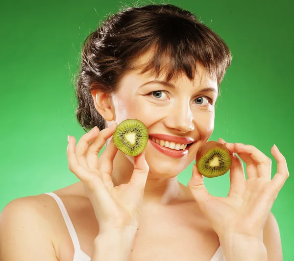 Mladý usmívající se žena hospodářství kiwi. — Stockfoto