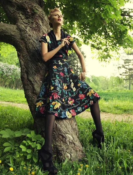 Молода жінка позує на дереві — стокове фото