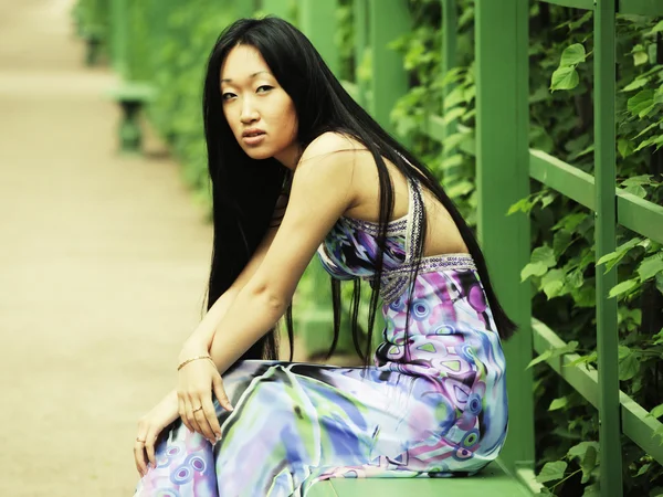 Aziatische vrouw zitten op de parkbank — Stockfoto